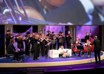 A conductor invited refugees who’d never played instruments to join his orchestra. It changed his life