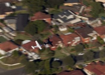 Small plane loses power and skims suburban rooftops before making crash landing on belly